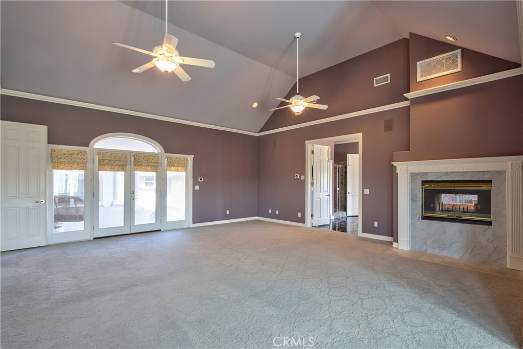46856 El Prado Road Temecula, CA 92590 - Photo 31 of 75 a view of an empty room with a chandelier fan and a fireplace