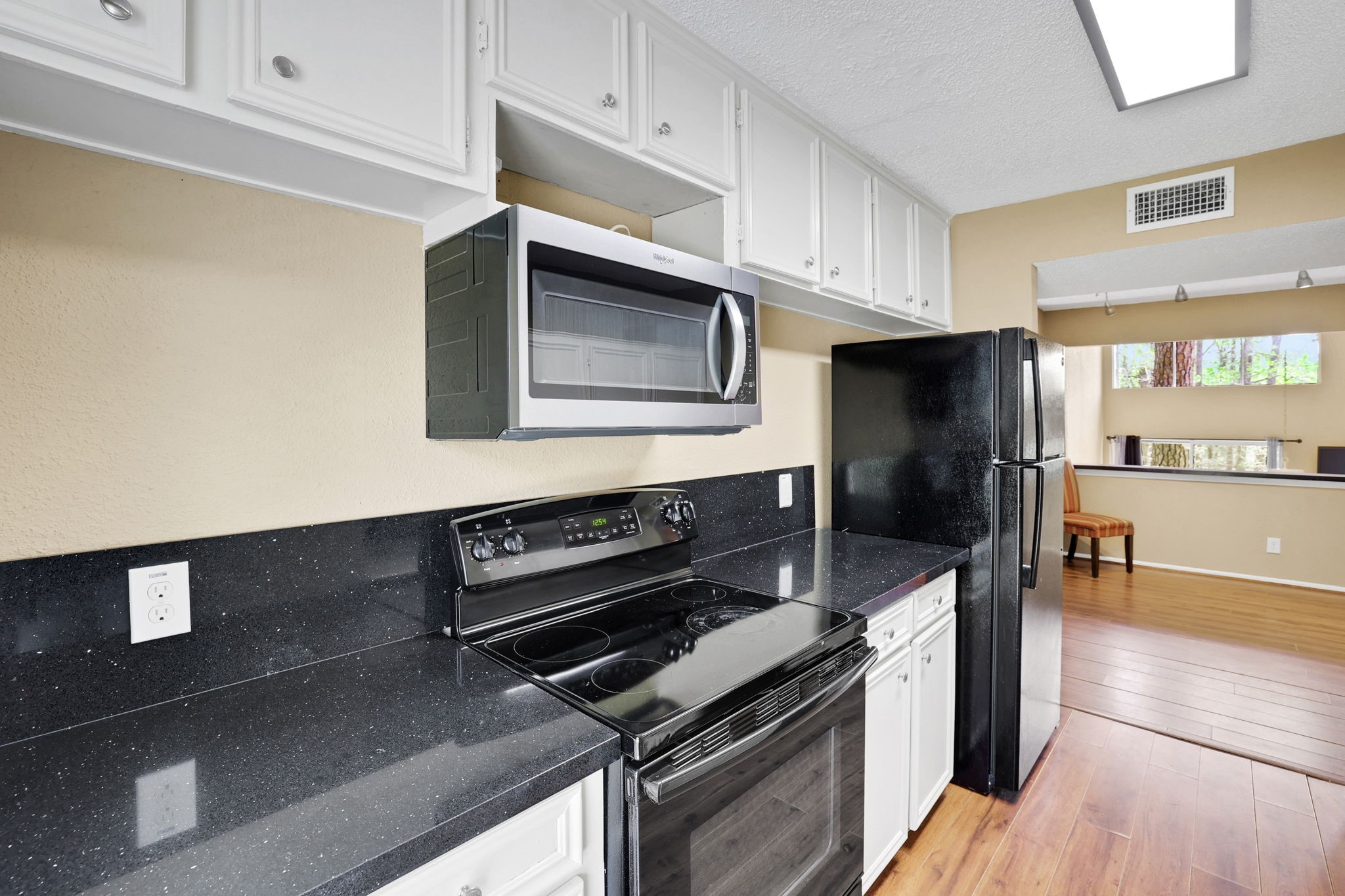 178 Villa Way Coldspring, TX 77331 - Photo 17 of 43 a kitchen with kitchen island granite countertop a stove and a microwave