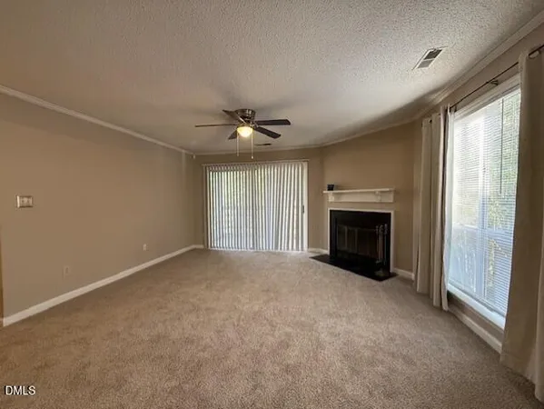 an empty room with windows and fireplace