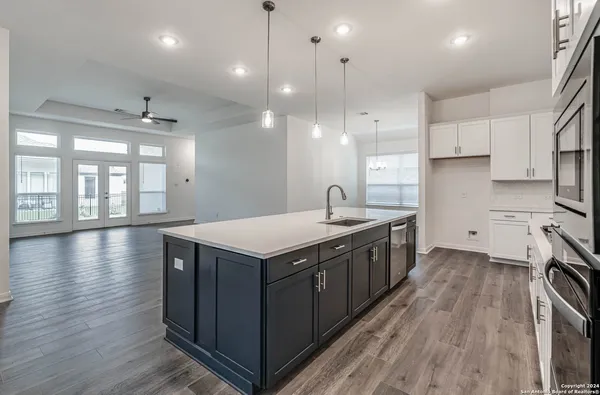 a kitchen with a sink a counter space appliances and cabinets