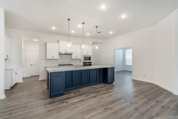 a kitchen with kitchen island granite countertop wooden cabinets and white appliances