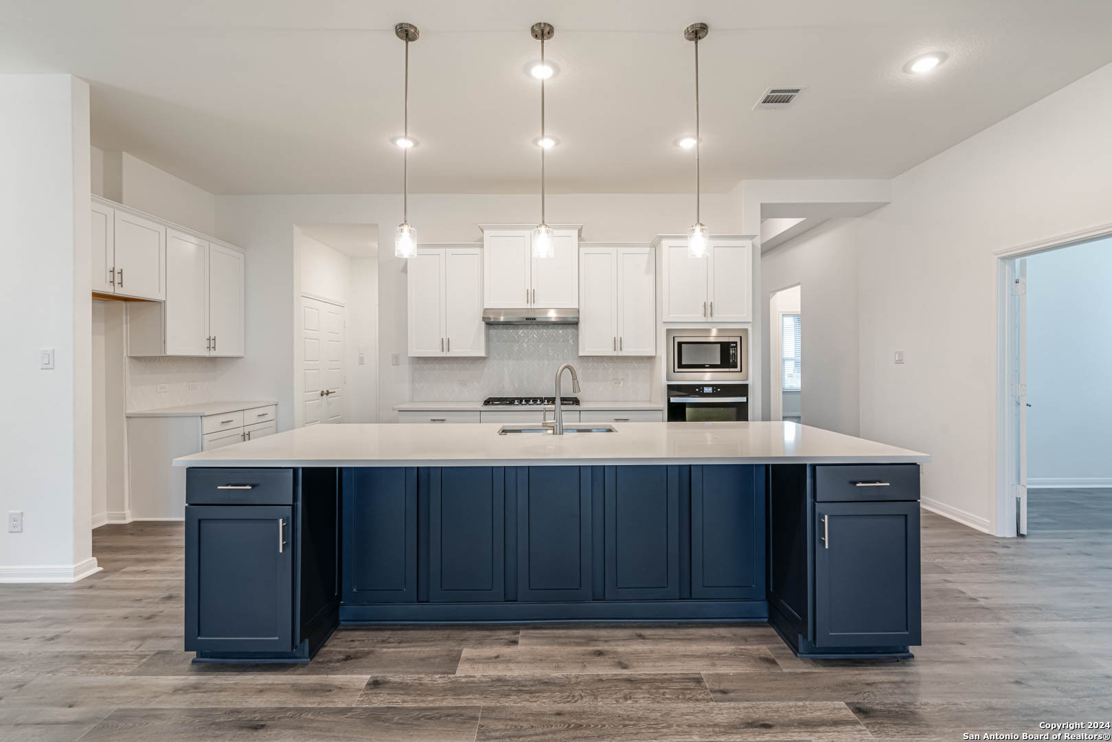 113 Valencia Boerne, TX 78006 - Photo 17 of 43 a kitchen with kitchen island granite countertop wooden cabinets and white appliances