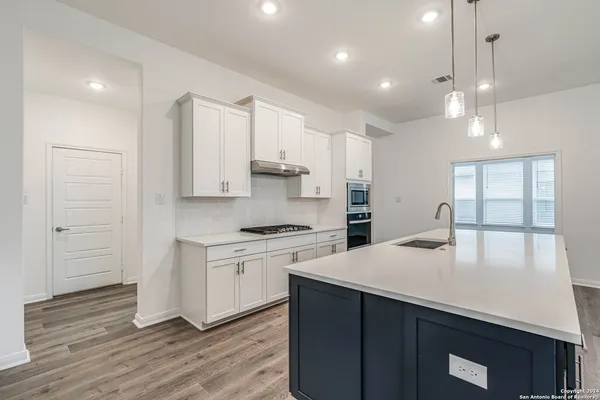 a kitchen with sink a stove and cabinets