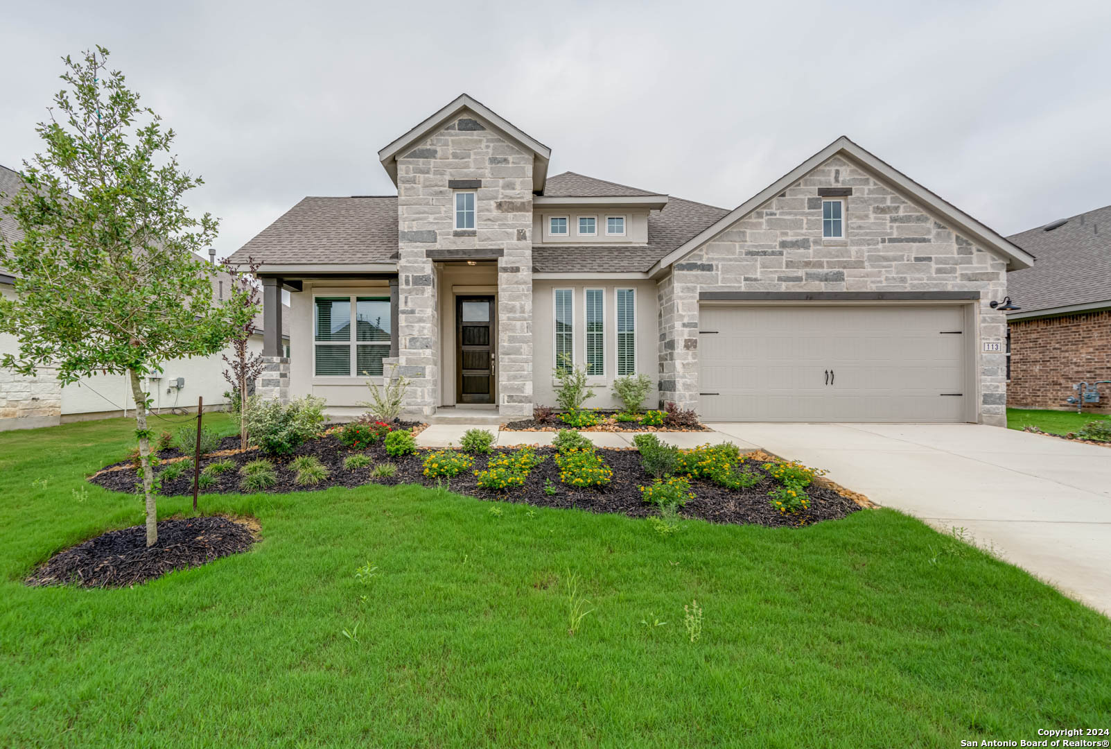 113 Valencia Boerne, TX 78006 - Photo 2 of 43 a front view of a house with a garden and plants