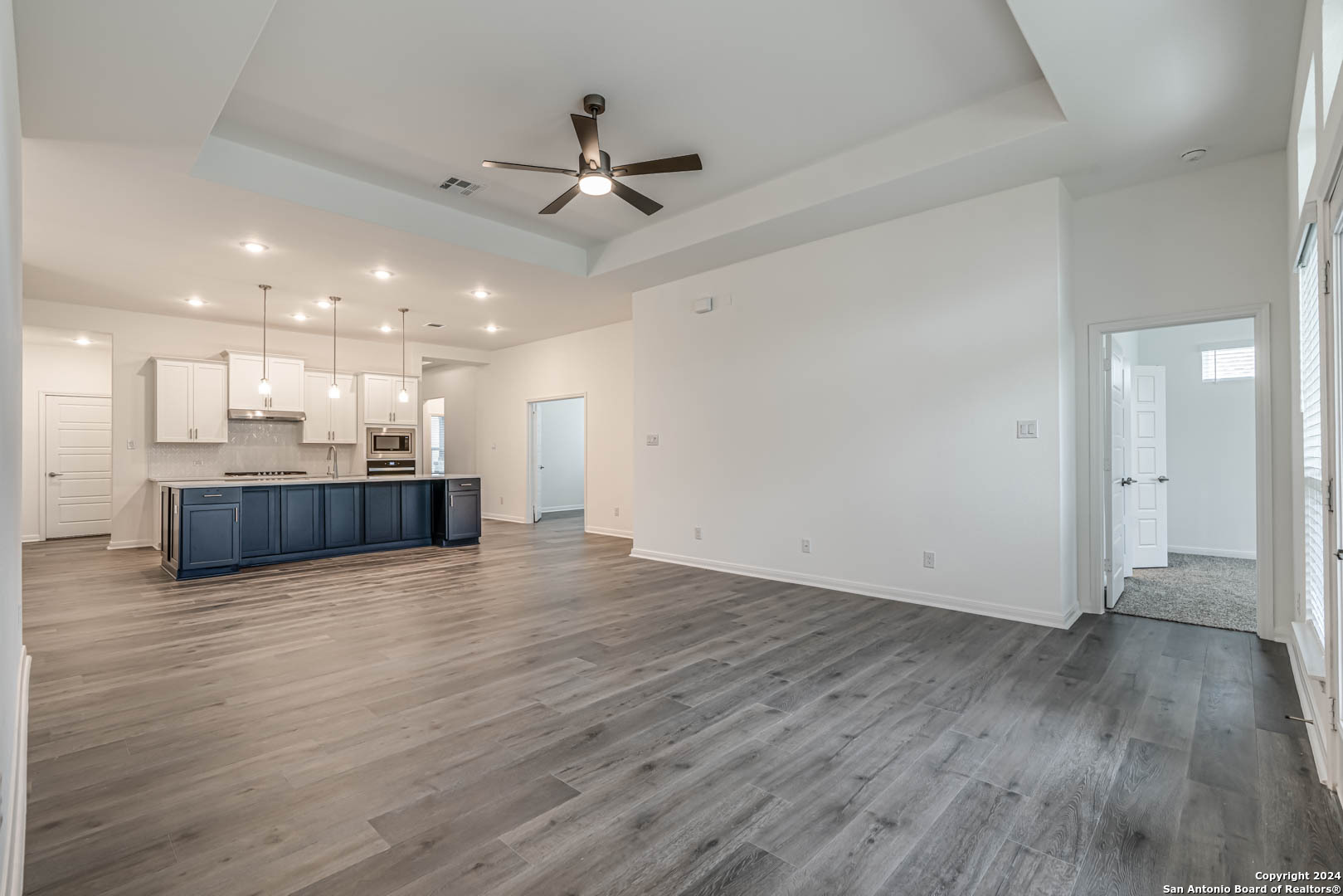 113 Valencia Boerne, TX 78006 - Photo 21 of 43 a view of an empty room with wooden floor and a ceiling fan