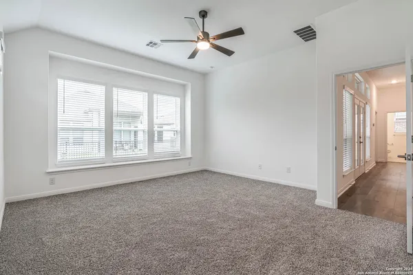 an empty room with closet and windows