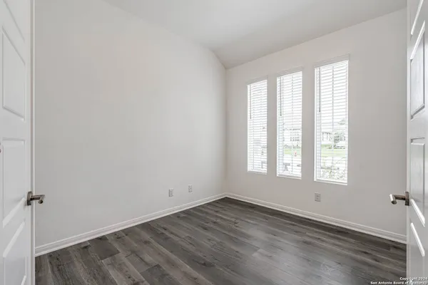 a view of an empty room with wooden floor