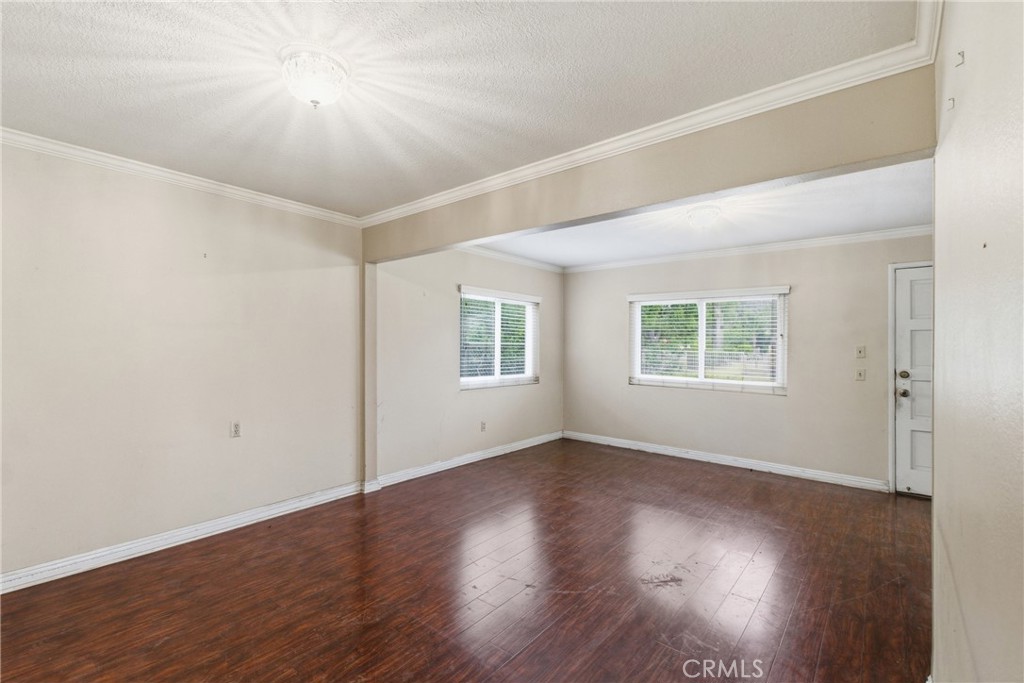 456 West Bennett Street Compton, CA 90220 - Photo 2 of 13 an empty room with wooden floor and windows