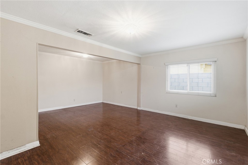 456 West Bennett Street Compton, CA 90220 - Photo 3 of 13 an empty room with wooden floor and windows