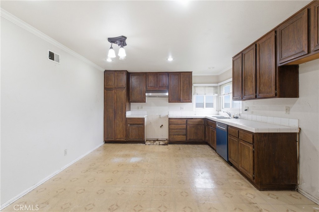 456 West Bennett Street Compton, CA 90220 - Photo 9 of 13 a kitchen with stainless steel appliances granite countertop a sink refrigerator and cabinets