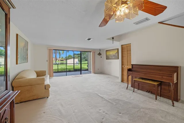 a living room with furniture a ceiling fan and a window