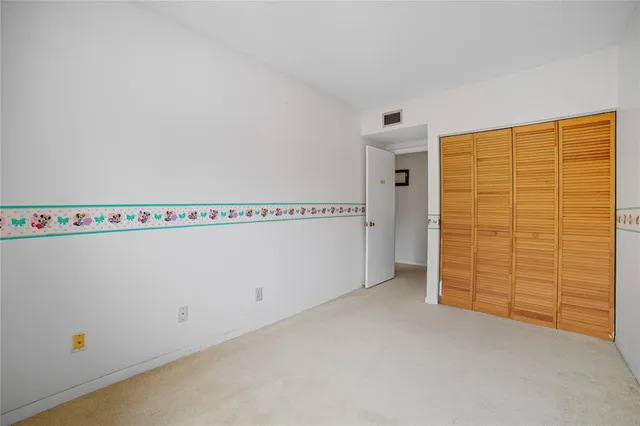 a view of a house with a yard and palm trees