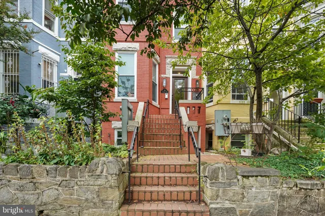 a view of a tall building with large windows and a yard