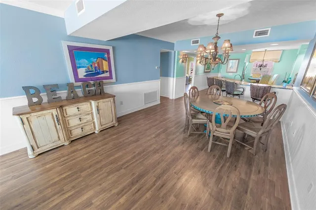 a kitchen with granite countertop a table chairs and wooden floor