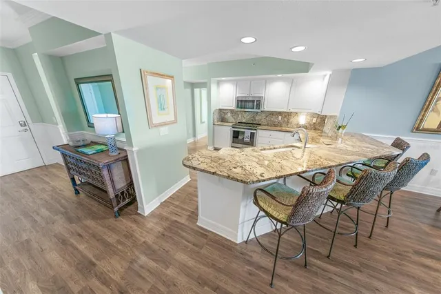 a kitchen with stainless steel appliances granite countertop a refrigerator a stove top oven a sink and dishwasher