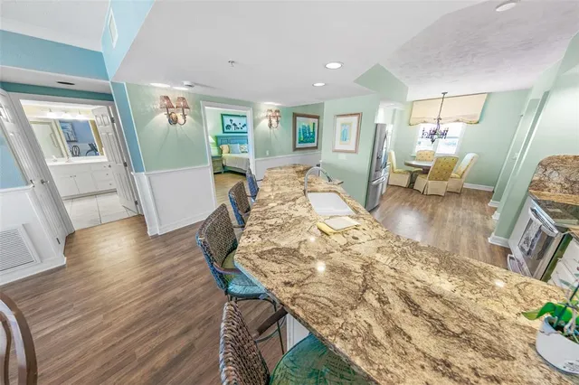 a bedroom with a bed a mirror on dresser and a wooden floor