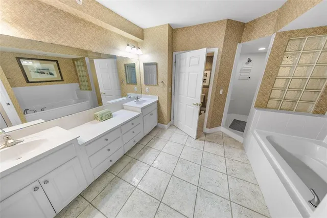 a spacious bathroom with a double vanity sink a mirror and a shower