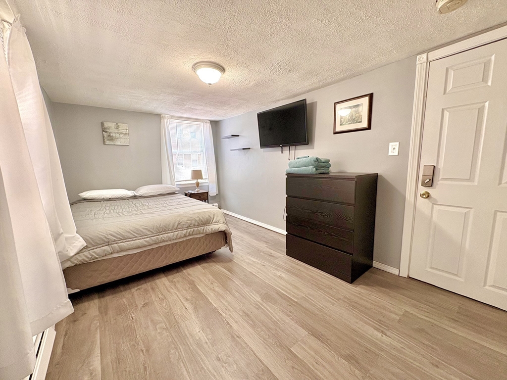285 Roxbury Street Boston, MA 02119 - Photo 12 of 15 a bedroom with a bed and a flat screen tv