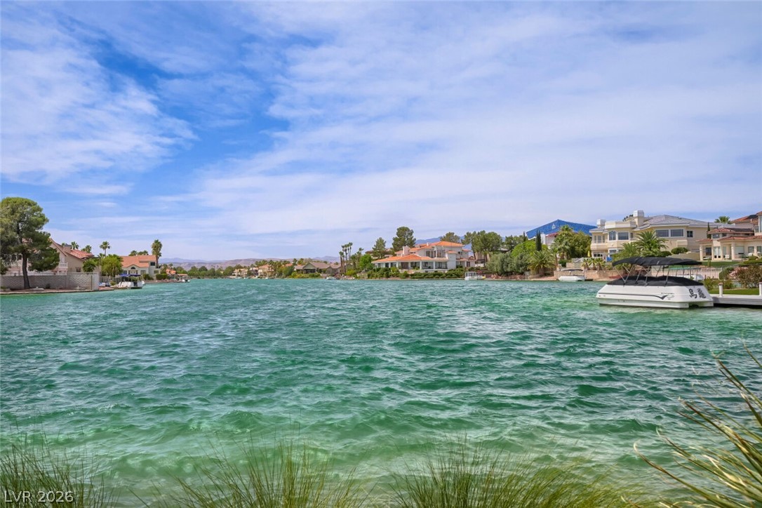 9325 West Desert Inn Road, Unit 177 Las Vegas, NV 89117 - Photo 2 of 24 Lakeside residences offer stunning water views and private boat access under a dynamic sky.