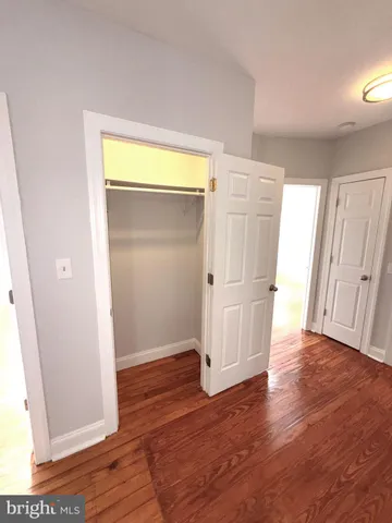 an empty room with wooden floor and a window