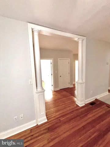 an empty room with wooden floor and door