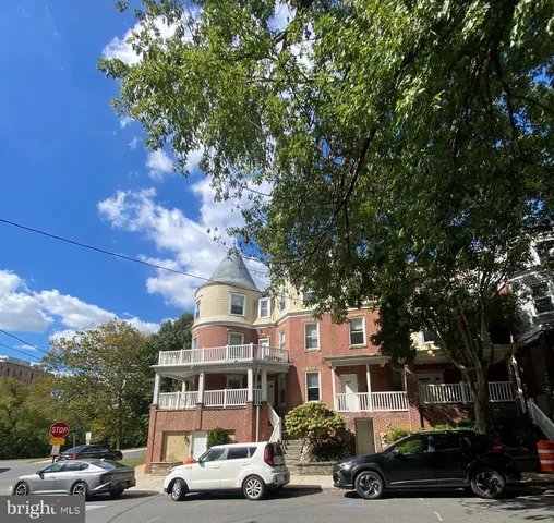 a front view of a building with trees