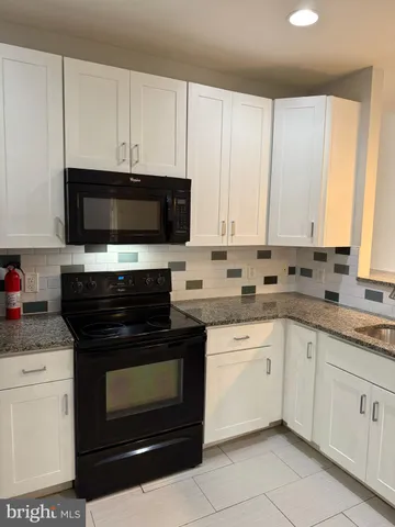 a kitchen with stainless steel appliances granite countertop a stove microwave and cabinets