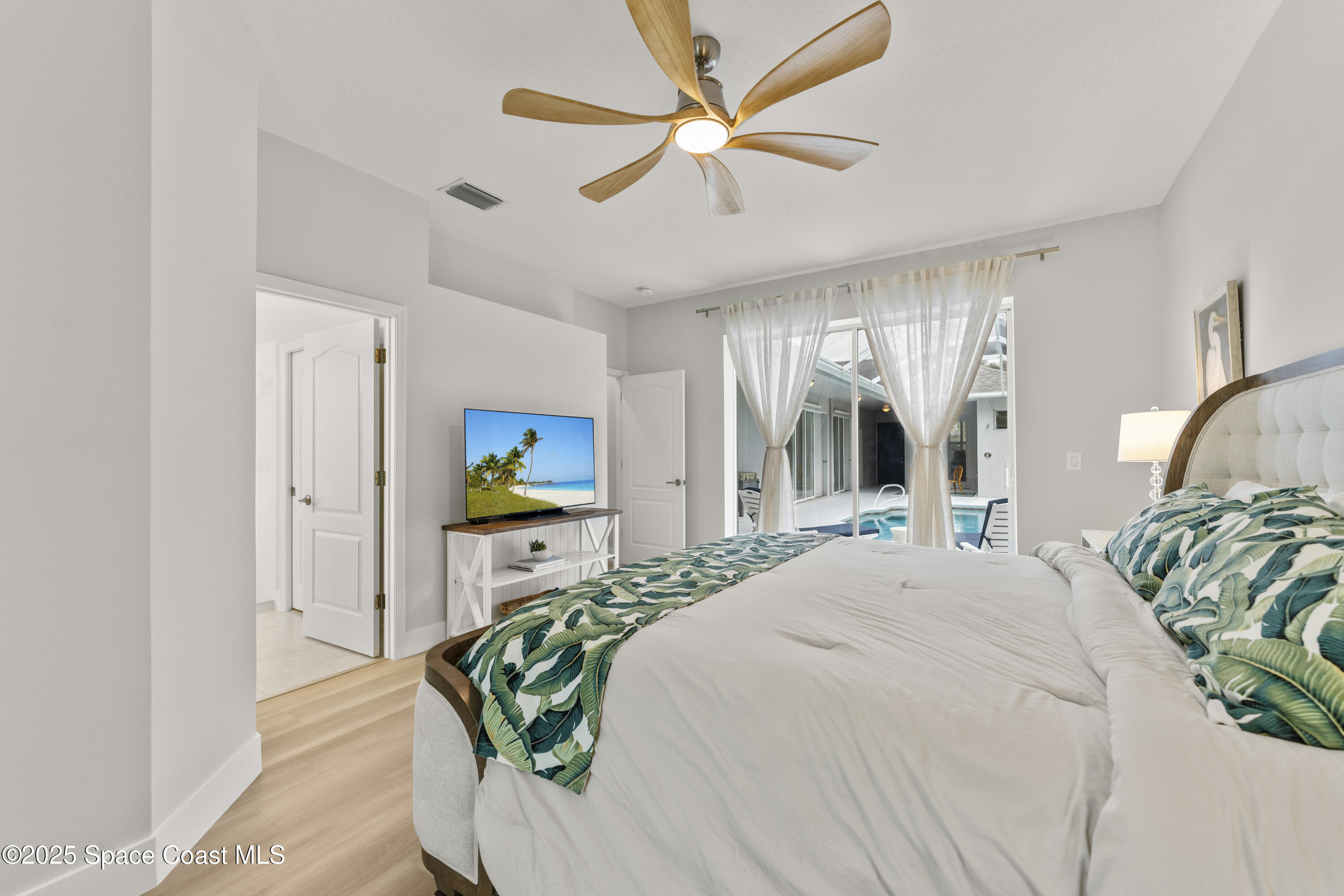 3053 Jacobaeus Lane Indialantic, FL 32903 - Photo 20 of 35 a bedroom with a bed and a chandelier