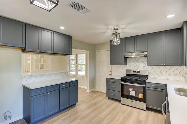 a kitchen with granite countertop wooden cabinets and a stove