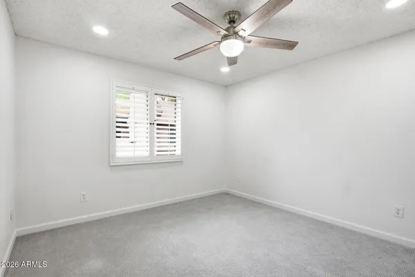 an empty room with a fan and a fan