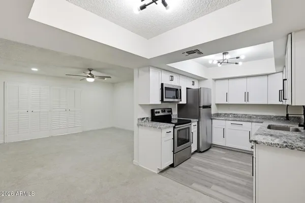 a kitchen with stainless steel appliances granite countertop a sink and a stove
