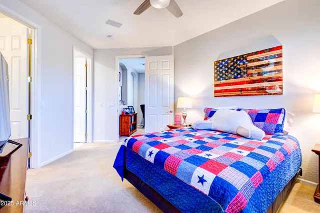 a bedroom with a bed and a painting on the wall