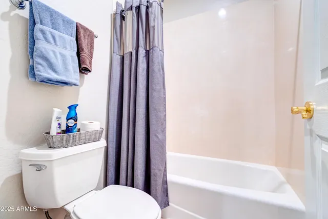 a white toilet sitting next to a bathroom sink and tub