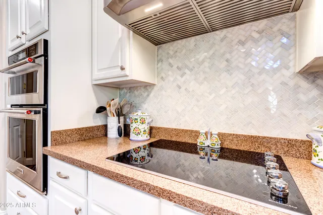 a kitchen with white cabinets and stainless steel appliances
