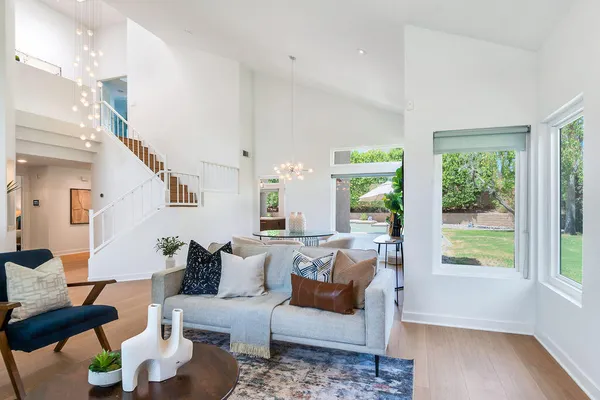 a living room with furniture a large window and a fireplace