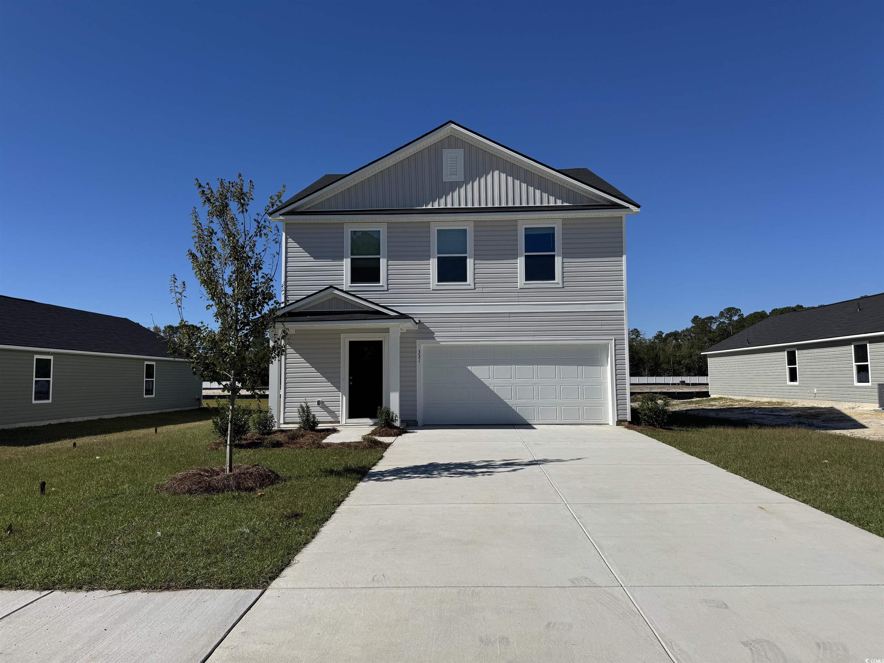 331 Mistletoe Way Longs, SC 29568 - Photo 1 of 7 View of front facade featuring board and batten siding, an attached garage, a front yard, and driveway