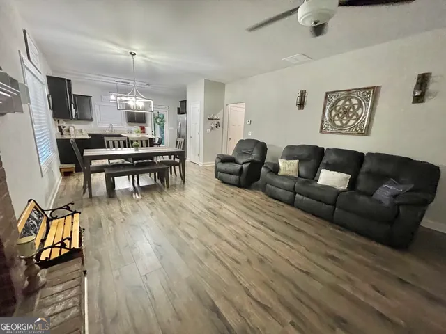 a living room with furniture a flat screen tv and kitchen view