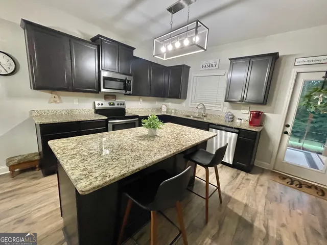 a spacious bedroom with a bed and a flat tv screen on dresser