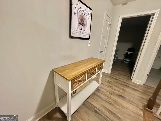 a bedroom with a bed and a dresser with the shoe rack