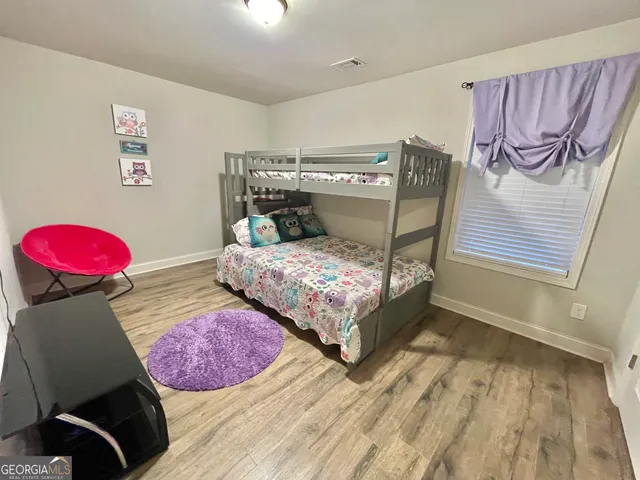 a view of a room with wooden floor furniture and windows