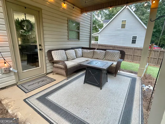 a view of a patio with couches and a table and chairs with garden view