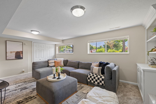 2370 Quail Run Circle East Sandy, UT 84093 - Photo 23 of 54 Carpeted lower-level living area featuring two windows, recessed lighting, built-in shelving, and bifold closet doors
