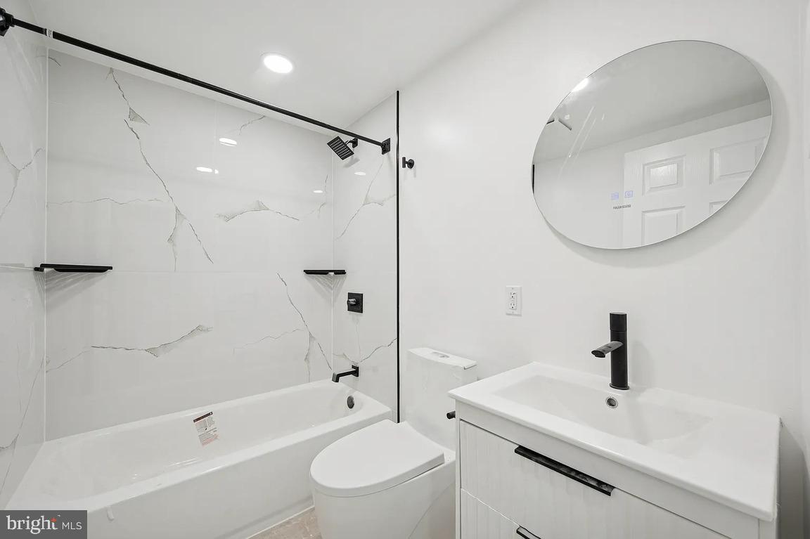 52 North 51st Street, Unit 1 Philadelphia, PA 19139 - Photo 4 of 7 a bathroom with a sink a toilet and a mirror