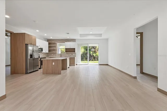 a large kitchen with stainless steel appliances granite countertop a stove a refrigerator a sink dishwasher and a oven with wooden floor