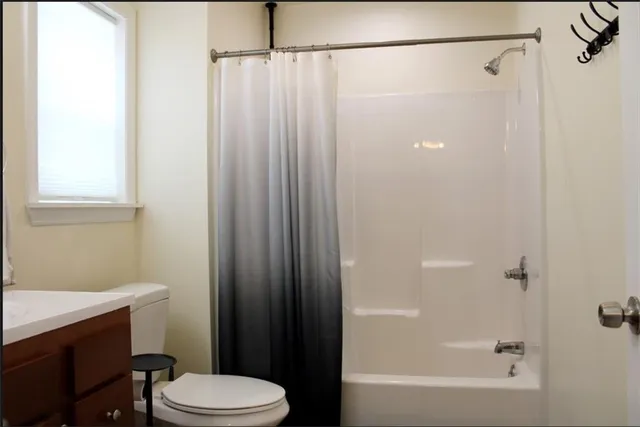 a bathroom with a shower a toilet and a sink