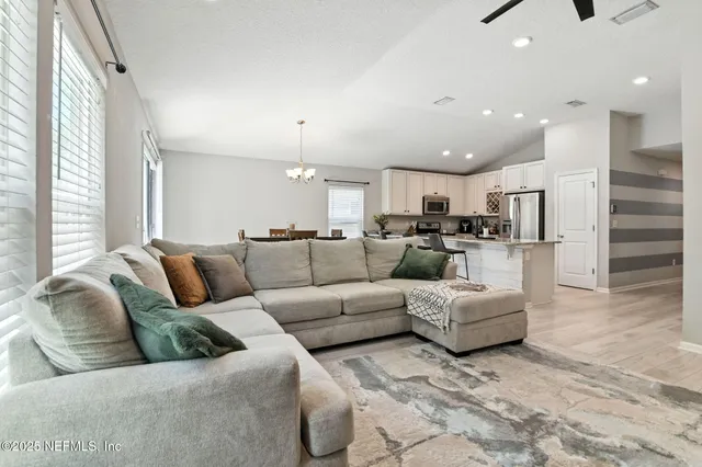 a living room with furniture and kitchen view