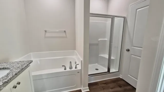 a bathroom with a granite countertop bathtub shower and toilet