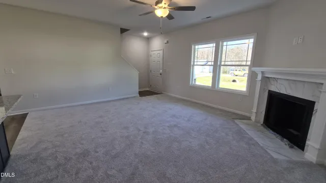 an empty room with windows and fireplace