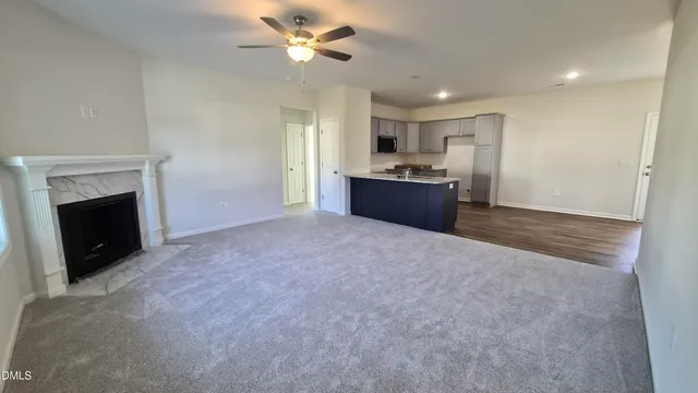 a large kitchen with a fireplace and a ceiling fan