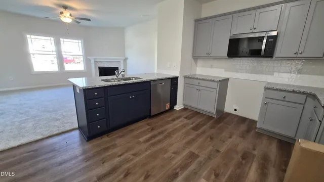 a kitchen with granite countertop a sink and a stove top oven